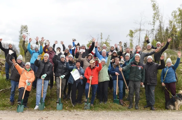 Eine Gruppe an Menschen posiert für ein Foto in der Natur. 